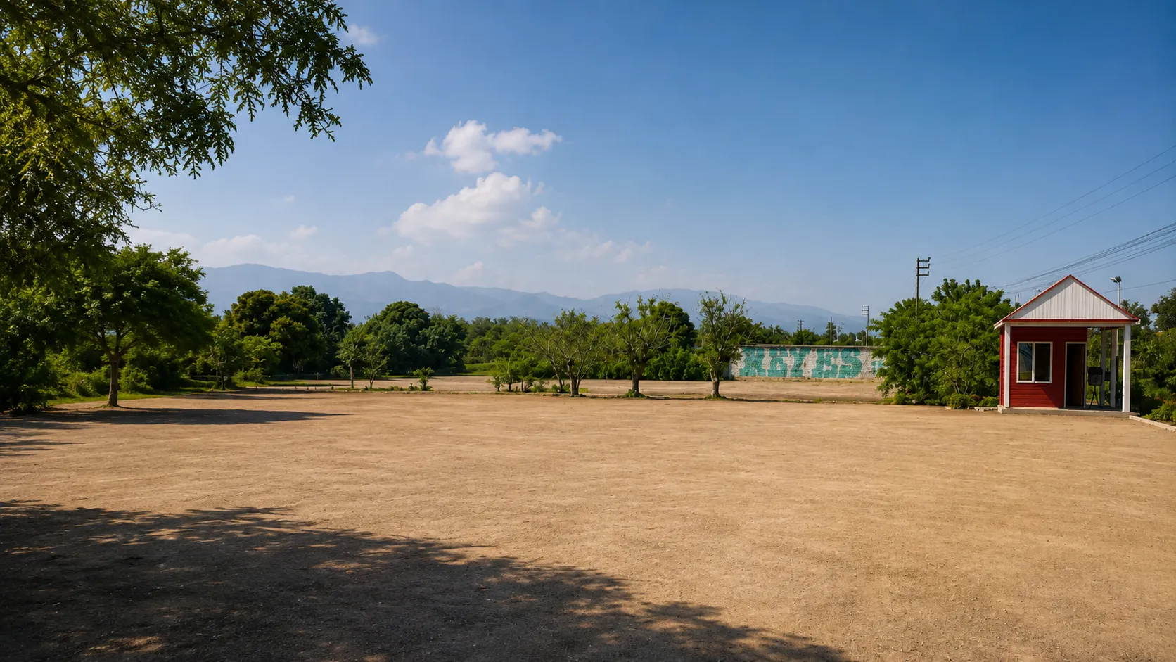Terreno del condominio Cruz Corcovada en Ica: explanada de tierra, arboleda y montañas al fondo
